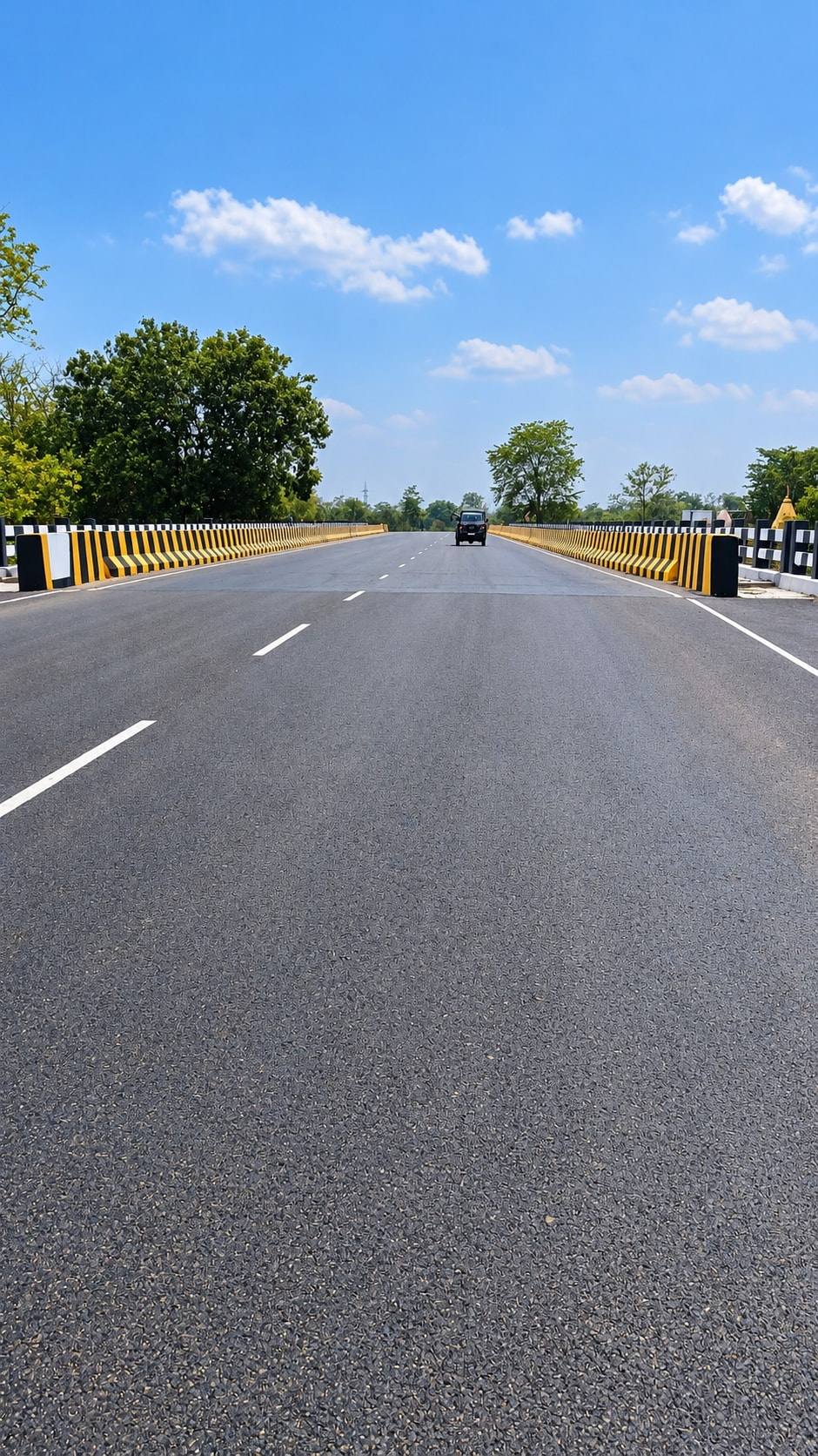 Completed deck of the NH-930 high-level bridge with painted crash barriers on both sides