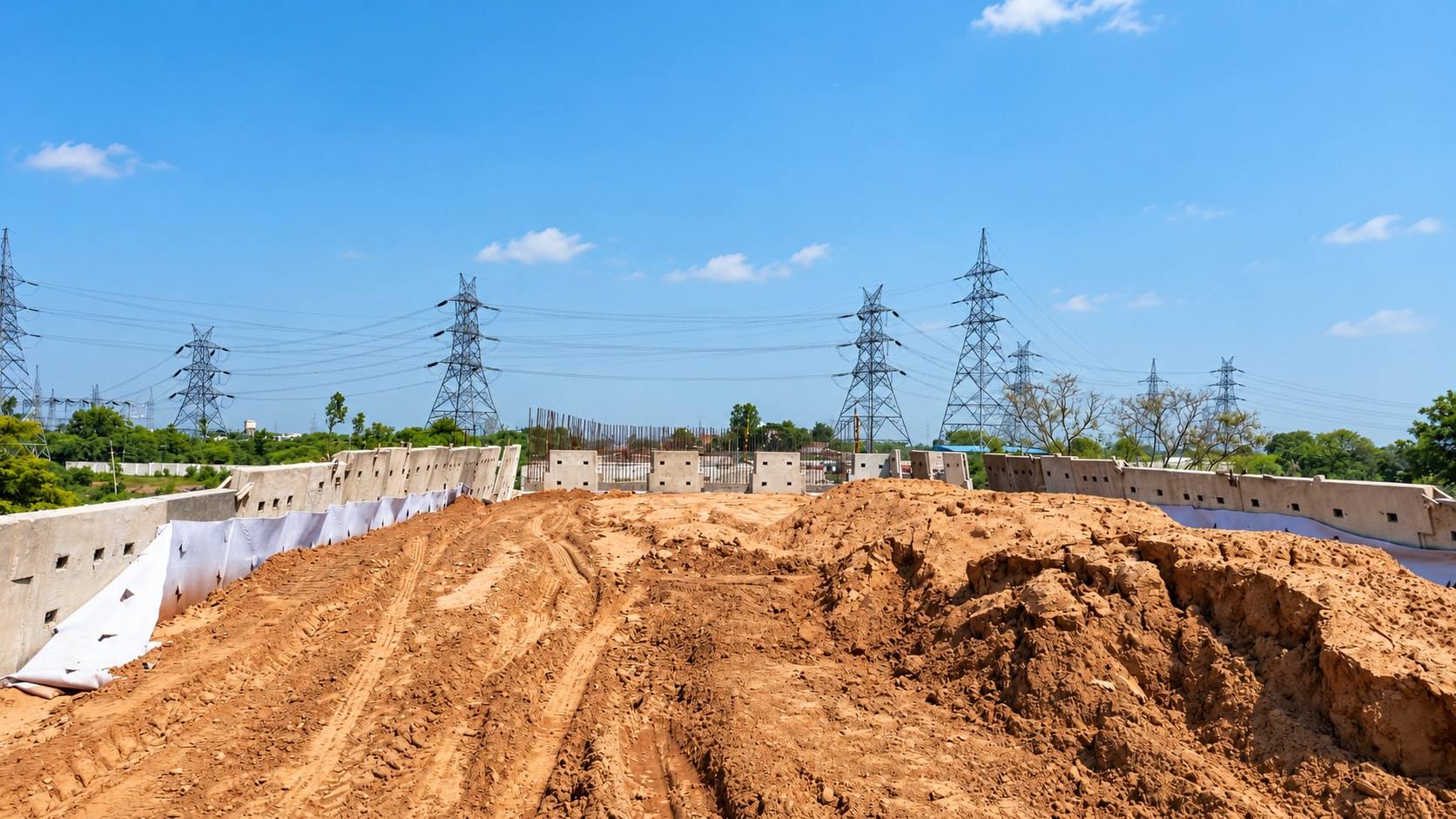 Earth embankment between two reinforced earth walls, with transmission towers in the distance